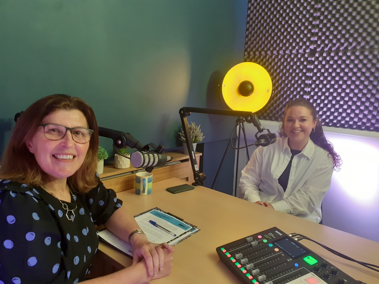 2 ladies sitting in the BBNI podcast studio, about to record a podcast