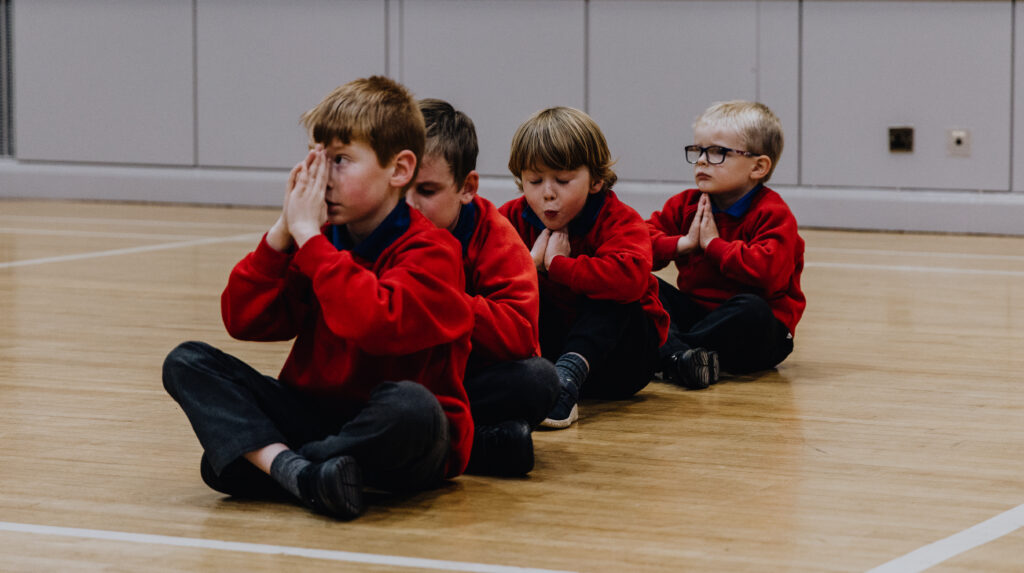 anchor boys sitting on the floor praying